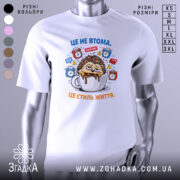 Футболка це не втома. Біла футболка з принтом, зображення їжачка, що сидить у чашці з кавою, на фоні з годинниками та значками, ракурс спереду, гладка текстура тканини.