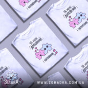 Футболка ти мене доповнив, біла, зображена на манекені, фон світло-сірий, принт з двома кольоровими пазлами: рожевим і блакитним, з усмішками та сердечками.