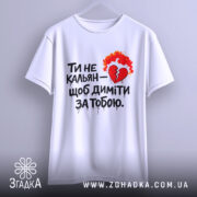 Футболка ти не кальян. Біла футболка з коротким рукавом, підвішена на вішалці. Принт на футболці з червоним серцем та вогнем, текст чорного кольору. Фон світло-сірий.