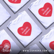 Футболка ти особлива людина. Біла футболка з червоним принтом у формі серця, на якому написано 'Ти особлива людина'. Футболка представлена на манекені з нейтральним фоном.