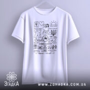 Футболка Україна мій світ, біла, підвішена на вішалці, фон світло-сірий, принт чорного кольору з різноманітними малюнками та написами, включаючи тризуб і сонце.