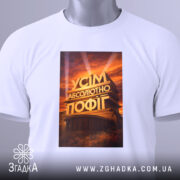 Футболка усім абсолютно пофіг. Біла футболка, зображена з верхнього ракурсу, принт на футболці з написом 'УСІМ АБСОЛЮТНО ПОФІГ', фон світлий, на футболці є етикетка з зеленим шнурком.