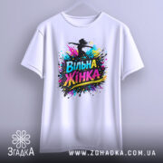 Футболка вільна жінка, білого кольору, зображена на вішалці, фон світло-сірий, принт з написом 'Вільна Жінка' у яскравих кольорах, з елементами спрею.