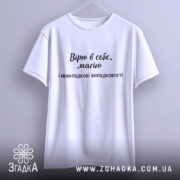 Футболка віра в себе, має білий колір, зображена з фронтального ракурсу, фон світло-сірий, принт чорного кольору з текстом "Вірю в себе, маю і невипадкові випадковості.".