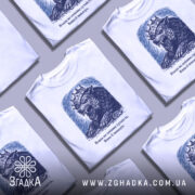 Футболка влада і сутність, білого кольору, зображена на манекені з правого боку, фон світло-сірий, принт з малюнком лева з короною в темно-синіх тонах, текст під малюнком.