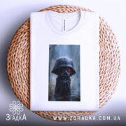 Футболка володар тіні, білого кольору, зображена на плетеній кошику, ракурс зверху, фон нейтральний, принт з персонажем у чорному капюшоні з червоними очима, футболка акуратно складена.