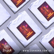 Футболка з фразою любові, біла, зображена в ракурсі спереду, фон нейтральний, принт з мишеням, що тримає сердечко, текст під малюнком: 'Тримай і не впендривайся'.