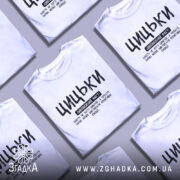 Футболка з написом цицьки, білого кольору, зображена на манекені з нейтральним фоном, принт чорного кольору з великими буквами, текст розташований по центру.