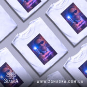 Футболка забудь і живи. Біла футболка з принтом, на якому зображено чоловіка в темних окулярах, що тримає світловий прилад. Принт яскравий, з фоновими кольорами, що створюють ефект світла.