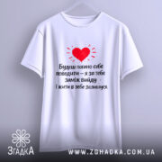 Футболка жарт про шлюб, біла, зображена на вішалці, фон світлий, принт червоного серця з текстом чорного кольору.