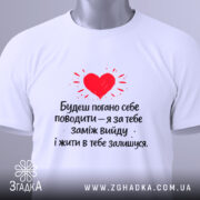 Футболка жарт про шлюб, біла, зображена зверху, фон світлий, принт червоного серця з текстом чорного кольору, на комірці є етикетка.