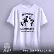 Футболка зла господиня, біла, зображена з фронтального ракурсу, фон світлий, принт чорного кольору з малюнком жінки, яка обережно підходить до чоловіка, поряд чорна собака.