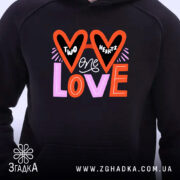 Худі до Дня Валентина, чорного кольору, з капюшоном, з кишенею-«кенгуру», з близьким ракурсом на принт з написом 'TWO HEARTS ONE LOVE', деталі принта в червоних, чорних і рожевих кольорах, манжети та пояс з еластичної тканини.