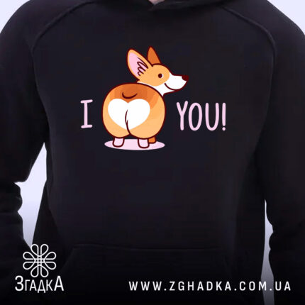 Худі I love you чорного кольору, з капюшоном, з акцентом на принт з коргі, що показує задню частину, з написом 'I YOU!' у світло-рожевому кольорі. Зображення зосереджене на верхній частині худі, без кишені на передньому плані.