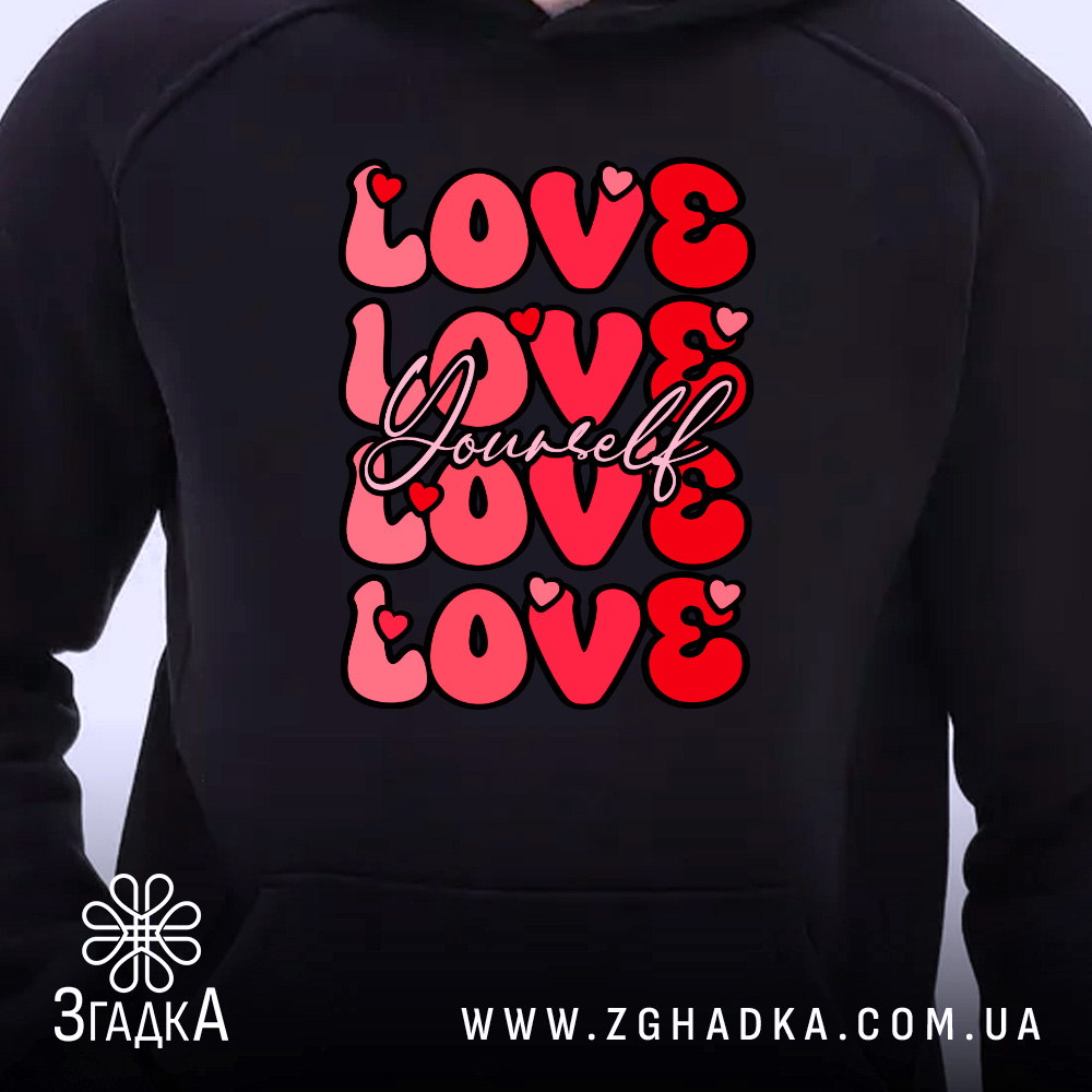 Худі Love Yourself чорного кольору, ракурс з близької відстані, фон світлий, принт з написом 'LOVE Yourself' червоного кольору, капюшон видимий, манжети та пояс з еластичної тканини.