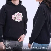 Худі стрітвеар Fuck Love, темно-синього кольору, з капюшоном, ракурс з боку, фон білий, принт з написом 'FUCK LOVE' у рожевих сердечках, є кишеня-«кенгуру», манжети та пояс з еластичної тканини, на моделі чоловік і жінка.