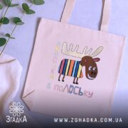 Шопер подарунок смішний лось — кілька складених шоперів, композиція на столі.