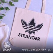 Шопер з принтом Stranger — кілька складених шоперів, композиція на столі.