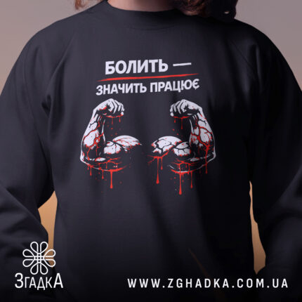 Світшот Болить значить працює, чорний колір, близький ракурс, фон нейтральний, деталі принта з м'язами та краплями крові, кругла горловина, манжети, трикотажна резинка на поясі, фактура м'яка і комфортна.