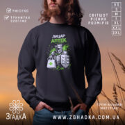 Світшот Лицар аптеки чорного кольору, зображений на чоловікові, який стоїть на фоні заходу сонця. Принт з лицарем у броні з аптечною сумкою та зеленими акцентами. Кругла горловина, манжети та трикотажна резинка на поясі, фактура м'яка та приємна на дотик.