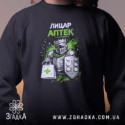 Світшот Лицар аптеки чорного кольору, зосереджений на верхній частині, показує принт з лицарем, що тримає аптечну сумку. Кругла горловина, манжети та трикотажна резинка на поясі, фактура м'яка та комфортна.