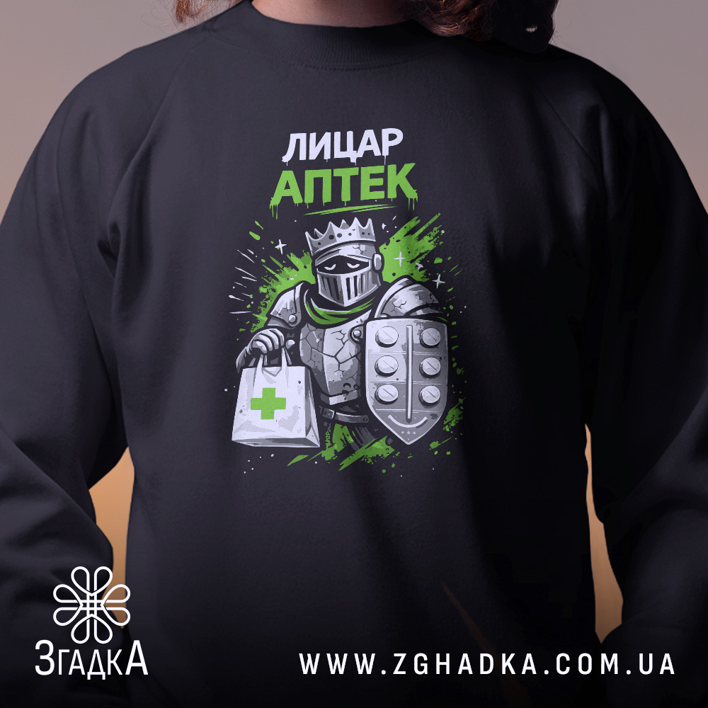 Світшот Лицар аптеки чорного кольору, зосереджений на верхній частині, показує принт з лицарем, що тримає аптечну сумку. Кругла горловина, манжети та трикотажна резинка на поясі, фактура м'яка та комфортна.