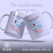 Чашка для коханого чоловіка, дві білих чашки з кольоровим принтом, зображені з легким нахилом, на фоні світло-блакитного градієнта. Принт містить текст червоного, синього та чорного кольорів, ручки округлі, краї рівні, поверхня глянцева.