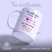 Чашка для коханої дружини, біла, з блискучою поверхнею, з написом чорного та рожевого кольорів, з сердечком, ручка з класичним дизайном, край рівний, нахилена вбік.