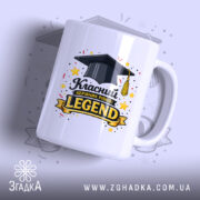 Чашка для легендарного класного керівника, біла з глянцевою поверхнею, зображення з чорним капелюхом випускника та написом 'Класний керівник рівня: LEGEND' у жовтому кольорі, ручка округлої форми, фон світло-фіолетовий з елементами зірок.