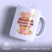 Чашка для найкращого вихователя, біла з яскравим принтом, на якому зображені квіти та напис 'Найкращий вихователь у садочку', ручка класична, край рівний, глянець на поверхні.