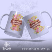 Чашка для найкращого вихователя, дві чашки під кутом, обидві з квітковим принтом та написом 'Найкращий вихователь у садочку', фон ніжно-фіолетовий, ручки стандартні, край рівний, глянець на поверхні.