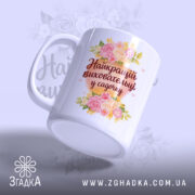 Чашка для найкращого вихователя, біла з квітковим принтом, напис 'Найкращий вихователь у садочку' на передній частині, ручка класична, край рівний, глянець на поверхні.