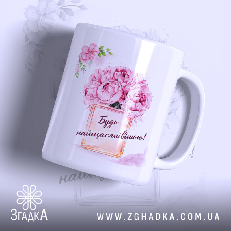 Чашка для подарунку на свято, біла з яскравим принтом, зображення квітів і написом "Будь найщасливішою!", ручка класична, край рівний, глянцеве покриття, фон світлий з легким малюнком квітів.