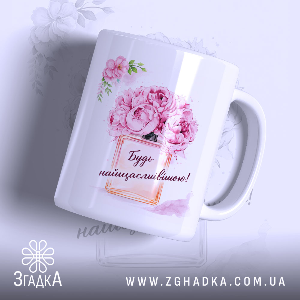 Chashka Dlia Podarunku Na Sviato Idealnyi Vybir 1 Чашка для подарунку на свято, біла з яскравим принтом, зображення квітів і написом "Будь найщасливішою!", ручка класична, край рівний, глянцеве покриття, фон світлий з легким малюнком квітів.