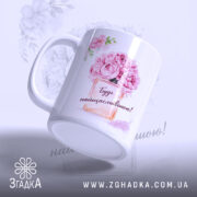 Чашка для подарунку на свято, біла з яскравим принтом, зображення квітів і написом "Будь найщасливішою!", ручка класична, край рівний, глянцеве покриття, фон світлий з легким малюнком квітів.
