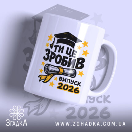 Чашка для випускника. Білий фон, ракурс з боку, на передньому плані великий напис "ТИ ЦЕ ЗРОБИВ" чорного кольору, під ним зображення диплома та напис "випуск 2026" жовтого кольору. Ручка кругла, край рівний, глянцеве покриття.