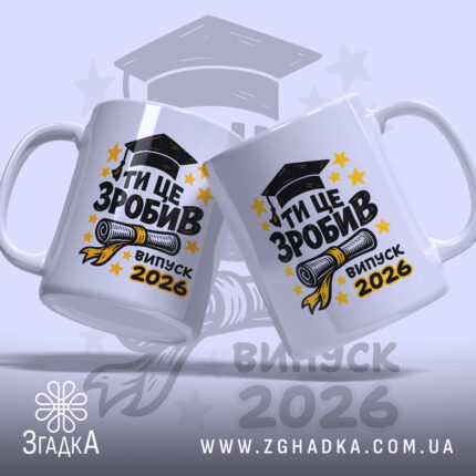 Чашка для випускника. Білий фон, ракурс з двох боків, на обох чашках великий напис "ТИ ЦЕ ЗРОБИВ" чорного кольору, під ним зображення диплома та напис "випуск 2026" жовтого кольору. Ручки круглі, краї рівні, глянцеве покриття.