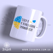 Чашка майбутнього пʼятикласника, біла з кольоровим принтом, зображення соняшника в жовто-блакитних кольорах, текст чорного кольору, ручка класична, край рівний, глянець.