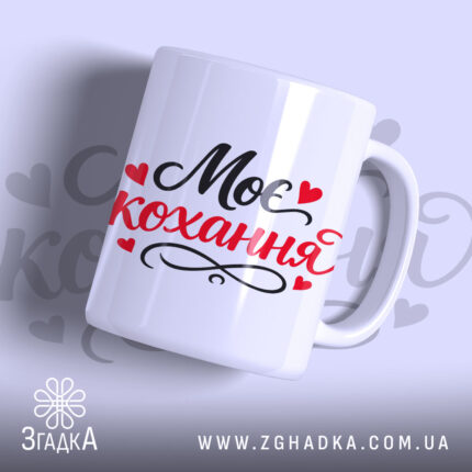 Чашка Моє кохання, біла з чорним і червоним написом "Моє кохання" та сердечками, з гладкою поверхнею, ручка з класичним вигином, край рівний, матова текстура.