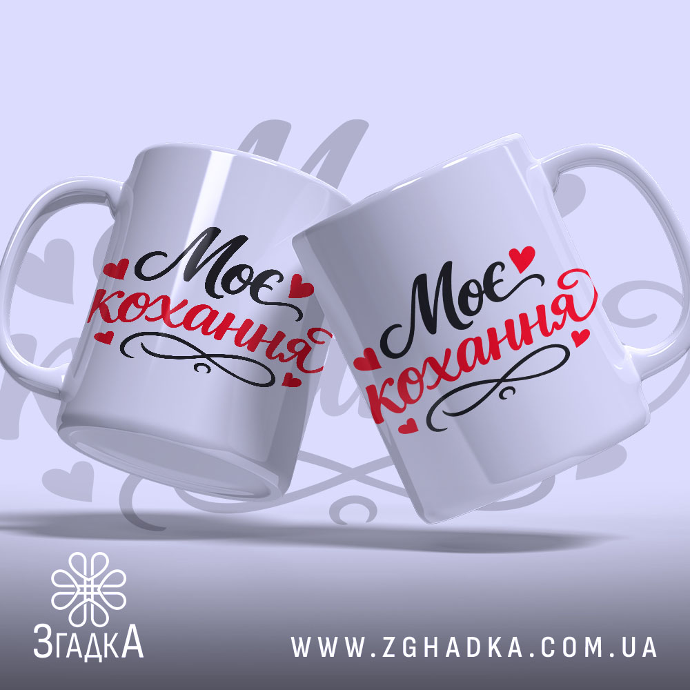 Чашка Моє кохання, дві чашки, обидві білі з чорним і червоним написом "Моє кохання" та сердечками, з гладкою поверхнею, ручки класичної форми, краї рівні, матова текстура.
