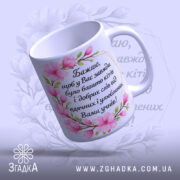 Чашка на подарунок вчителю, біла з рожевими квітами, ракурс з боку, фон світло-фіолетовий, напис чорний, ручка стандартна, край рівний, глянцевий.