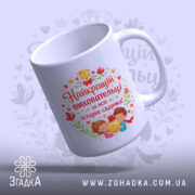 Чашка найкращій виховательці садочку, біла з кольоровим принтом, ракурс з верхнього боку, фон світло-фіолетовий, на принті зображення дітей з медаллю, текст червоним кольором, ручка стандартна, край рівний, глянцева поверхня.