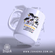 Чашка пам'ять про школу, біла, зображена з лівого ракурсу, фон світло-фіолетовий, принт з малюнками персонажів у капелюхах випускників та написом "Випуск-2026: Тут зберігаються найтепліші шкільні спогади", ручка класична, край рівний, глянцевий.