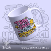 Чашка Сила в твоїй унікальності. Чашка білого кольору, що нахилена, з яскравим принтом на передній частині. Ручка гладка, край рівний, поверхня глянцева. Фон з легким градієнтом, що підкреслює кольори принта.