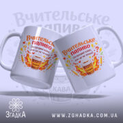 Чашка вчителю на подарунок, дві білі чашки, з бокового ракурсу, на світло-синьому фоні, з яскравими принтами, що містять напис 'Вчительське паливо' та малюнок чашки з кавою, ручки округлі, краї рівні, глянцеві.