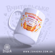 Чашка вчителю на подарунок, біла, з фронтального ракурсу, на світло-синьому фоні, з яскравим принтом, що містить напис 'Вчительське паливо' та малюнок чашки з кавою, ручка округлої форми, край рівний, глянцевий.