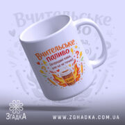 Чашка вчителю на подарунок, біла, з бокового ракурсу, на світло-синьому фоні, з яскравим принтом, що містить напис 'Вчительське паливо' та малюнок чашки з кавою, ручка округлої форми, край рівний, глянцевий.