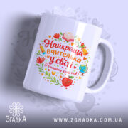 Чашка вчительці на свято, біла, з ракурсу спереду, на фоні з легким градієнтом, принт з написом "Найкраща вчителька у світі" та ілюстраціями олівця, книги, глобуса і квітів, ручка класична, край рівний, глянцевий.