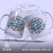 Чашка з мотиваційним написом, дві білі чашки з кольоровим принтом, показані з легким нахилом, на фоні світло-фіолетового кольору, напис виконаний у чорному, оранжевому та бірюзовому кольорах, ручки округлі, краї рівні, глянцеві.
