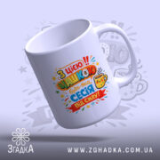 Чашка з принтом випускник. Білий колір, зображена з правого боку, фон світло-фіолетовий. Принт яскравий, з кольоровими написами та зображенням чашки, ручка гладка, край рівний, матова поверхня.
